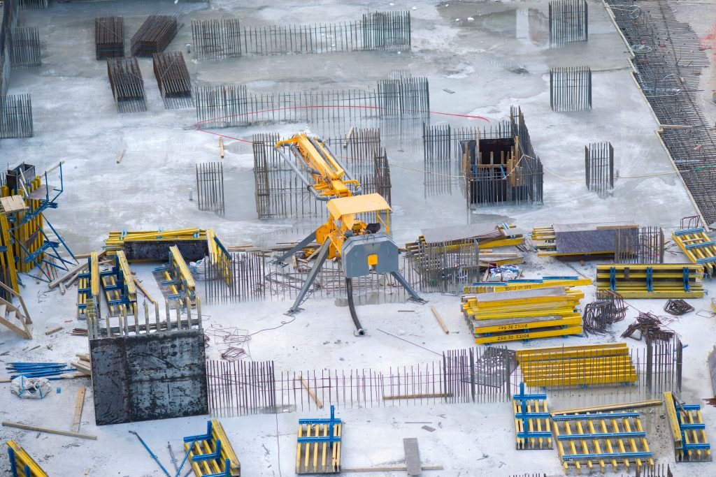 Nos Réalisations Aerial view of an active construction site with heavy machinery and building materials.